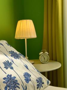 uma cama com um edredão azul e branco e uma mesa com um relógio em B&B Stella Scugnizza em Nápoles