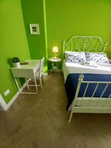 um quarto verde com uma cama e uma secretária em B&B Stella Scugnizza em Nápoles