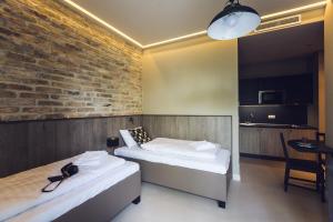 ブダペストにあるヘリテージ ホーム アパートメントのレンガの壁、ベッド2台が備わる客室です。