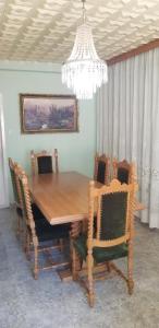 a dining room table with chairs and a chandelier at Apartment PER DAY in Vrbas