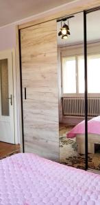 a bedroom with a large mirror and a bed at Apartment PER DAY in Vrbas