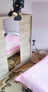 a mirror in a room with a bed and a ceiling fan at Apartment PER DAY in Vrbas