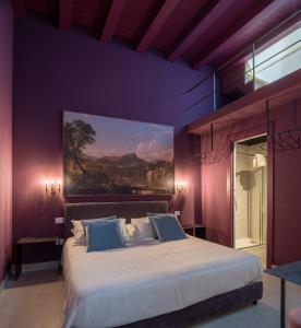 una camera da letto con un grande letto e un dipinto sul muro di ORTIGIAdreamrooms 14 a Siracusa