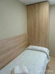 a small bed in a room with a wooden wall at Borja in Borja