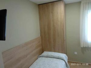 Habitación pequeña con cama y puerta de madera en Borja, en Borja