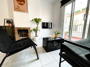 a living room with a chair and a fireplace at Tossa Center Attic & Terrace in Tossa de Mar
