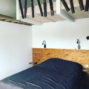 1 dormitorio con 1 cama con cabecero de madera en La cabane de Biscarrosse en Biscarrosse-Plage