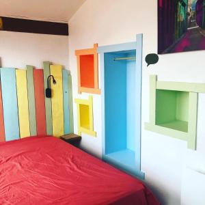 a room with a bed with colorful doors on the wall at La cabane de Biscarrosse in Biscarrosse-Plage