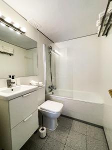 a bathroom with a toilet and a sink and a tub at Tossa Center Attic & Terrace in Tossa de Mar