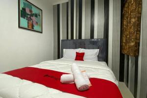 a bed with two towels on top of it at RedDoorz Plus @ Rawamangun in Jakarta