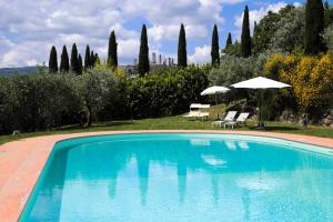 - une piscine avec 2 parasols et 2 chaises dans l'établissement Le Rose di Montagnana, à San Gimignano