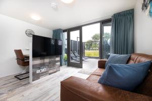 a living room with a couch and a flat screen tv at Vakantiewoning Bed & Bernard in Domburg