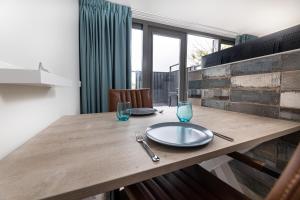 a dining table with a plate and glasses on it at Vakantiewoning Bed & Bernard in Domburg