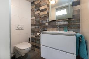 La salle de bains est pourvue de toilettes, d'un lavabo et d'un miroir. dans l'établissement Vakantiewoning B & Bernard, à Domburg