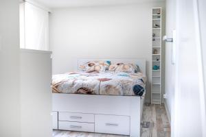 een slaapkamer met een bed in een witte kamer bij Vakantiewoning B & Bernard in Domburg