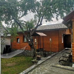 a log cabin with a hammock in front of it at Kotiedzh u Mariny in Yaremche