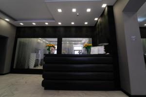 a lobby with a black counter with flowers on it at Sweet Central Hotel in Caserta