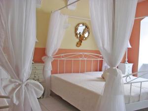 a bedroom with a bed with white curtains and a mirror at Apartment Storchenfärbe in Memmingen