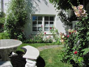 a garden with a table and flowers in front of a window at Apartment Storchenfärbe in Memmingen +45 photos