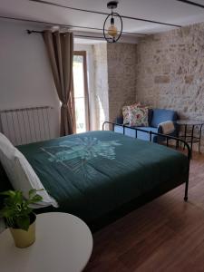 1 dormitorio con 1 cama con manta verde en Casa di Carmine 1915 - Solo Adulti, en Gamberale