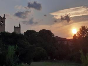 ein Sonnenuntergang über einer Stadt mit Bäumen und Gebäuden in der Unterkunft SENTIMIR in Saint-Génis + 1 Foto