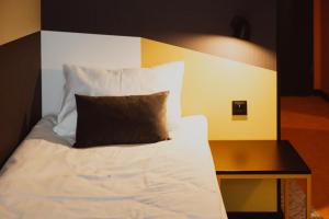 uma cama com uma cabeceira em preto e branco ao lado de uma mesa em Arche Hotel Piła em Piła