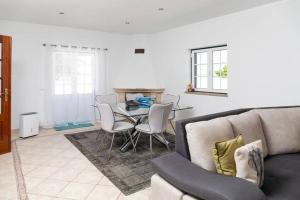 a living room with a couch and a table with chairs at NuvemCristina in Olho Marinho