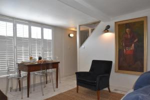 a living room with a desk and chair and a painting at Matchbox in Winchelsea