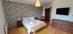 a bedroom with a bed and a tv on a wall at NuvemCristina in Olho Marinho +32 photos