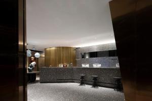 a lobby with a bar with stools in it at Arthur Hotel Canton Tower Guangzhou-广州塔骑士物语酒店 in Guangzhou