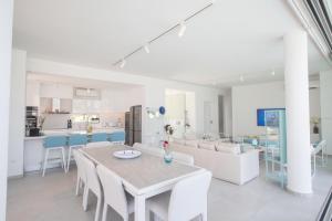 a dining room and kitchen with a table and chairs at Villa Olivine Pearl 3 in Protaras