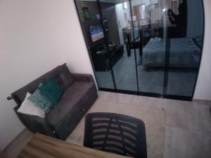 uma sala de estar com um sofá e um espelho em Aconchego da Floresta em Angra dos Reis
