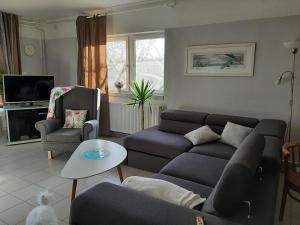 Sirokkó Apartman في بالاتونفوريد: غرفة معيشة مع أريكة وطاولة
