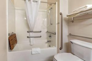 a white bathroom with a shower and a toilet at MainStay Suites Dubuque at Hwy 20 in Dubuque