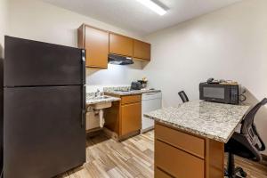 a kitchen with a refrigerator and a counter top at MainStay Suites Dubuque at Hwy 20 in Dubuque
