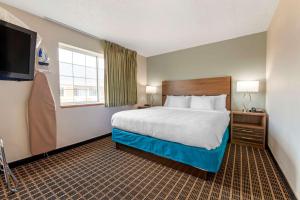 ein Hotelzimmer mit einem Bett und einem Flachbild-TV in der Unterkunft MainStay Suites Dubuque at Hwy 20 in Dubuque