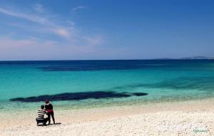 Zwei Personen stehen an einem Strand und schauen aufs Meer. in der Unterkunft Belvedere in Silba