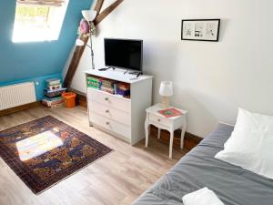 1 dormitorio con cama y vestidor con TV en La Maison des Remparts - Gite 3 etoiles pour 8 pers a Loches, en Loches