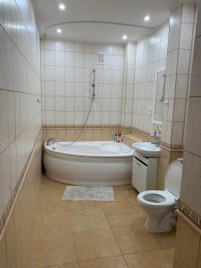 a bathroom with a tub and a toilet and a sink at 2-комнатная квартира на Соборной in Mykolaiv
