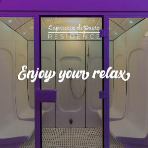 a bathroom with two urinals and the words enjoy your relax at CAPRICCIO Di PASTA SPA CAMERA LUXURY in Gragnano