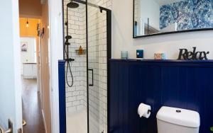 a bathroom with a blue shower stall and a toilet at Marine Sands - luxury apartment in Scarborough
