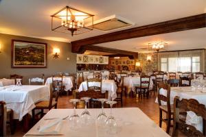 una sala da pranzo con tavoli e sedie bianchi di Hostería de Guara a Bierge