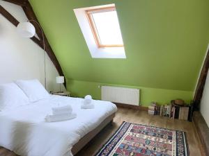 1 dormitorio con cama blanca, ventana y alfombra en La Maison des Remparts - Gite 3 etoiles pour 8 pers a Loches, en Loches