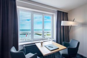 a room with a table and a window with a view of the beach at Hotel Atlantic in Wimereux