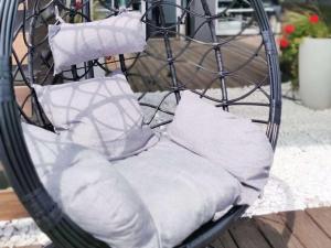 a iron chair with pillows on a porch at IBIS Styles Kaunas Centre in Kaunas