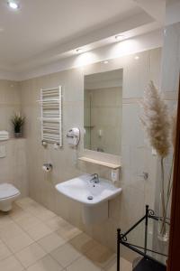 a bathroom with a sink, toilet, and mirror at Eurohotel Swarzędz in Swarzędz