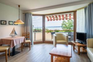 a living room with a view of the ocean at Hotel Seepark Appartements in Uhldingen-Mühlhofen