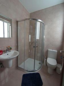 uma casa de banho com um chuveiro, um WC e um lavatório. em F7 Modern and Bright Apartment in Malta em Msida