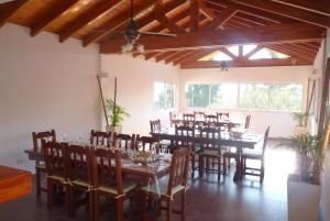 uma grande sala de jantar com mesas, cadeiras e janelas em Hotel Aoma Villa Carlos Paz em Villa Carlos Paz