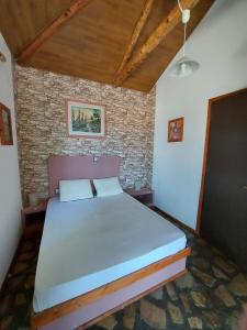 a bedroom with a large bed in a brick wall at Beautiful house located on a hill with a spectacular sea view in Samos Island in Koumeika